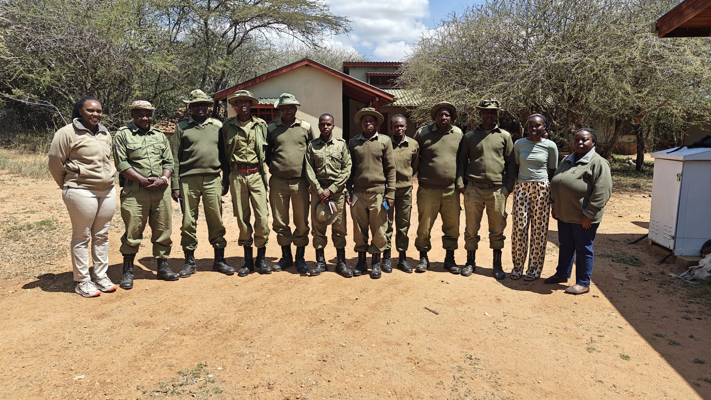 A conservancy ranger team with Wildlife Health Watch trainers outside a field station