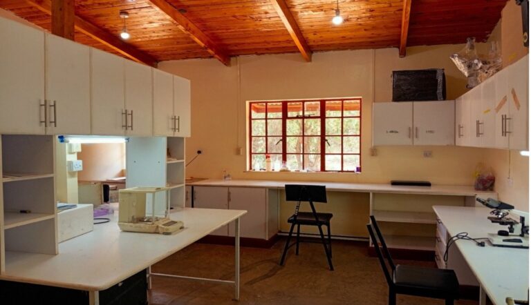 Wet lab at Mpala with white benches, wall cabinets and stools under a timber ceiling
